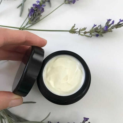 Face cream in a black round open box